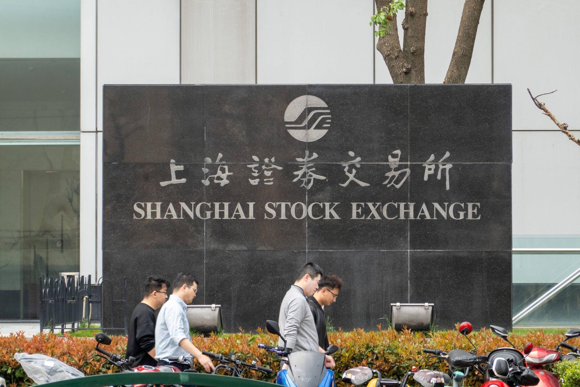 Börse von Shanghai Bürger gehen an der Börse von Shanghai vor dem Lujiazui Securities Building in Pudong, Shanghai, China, vorbei