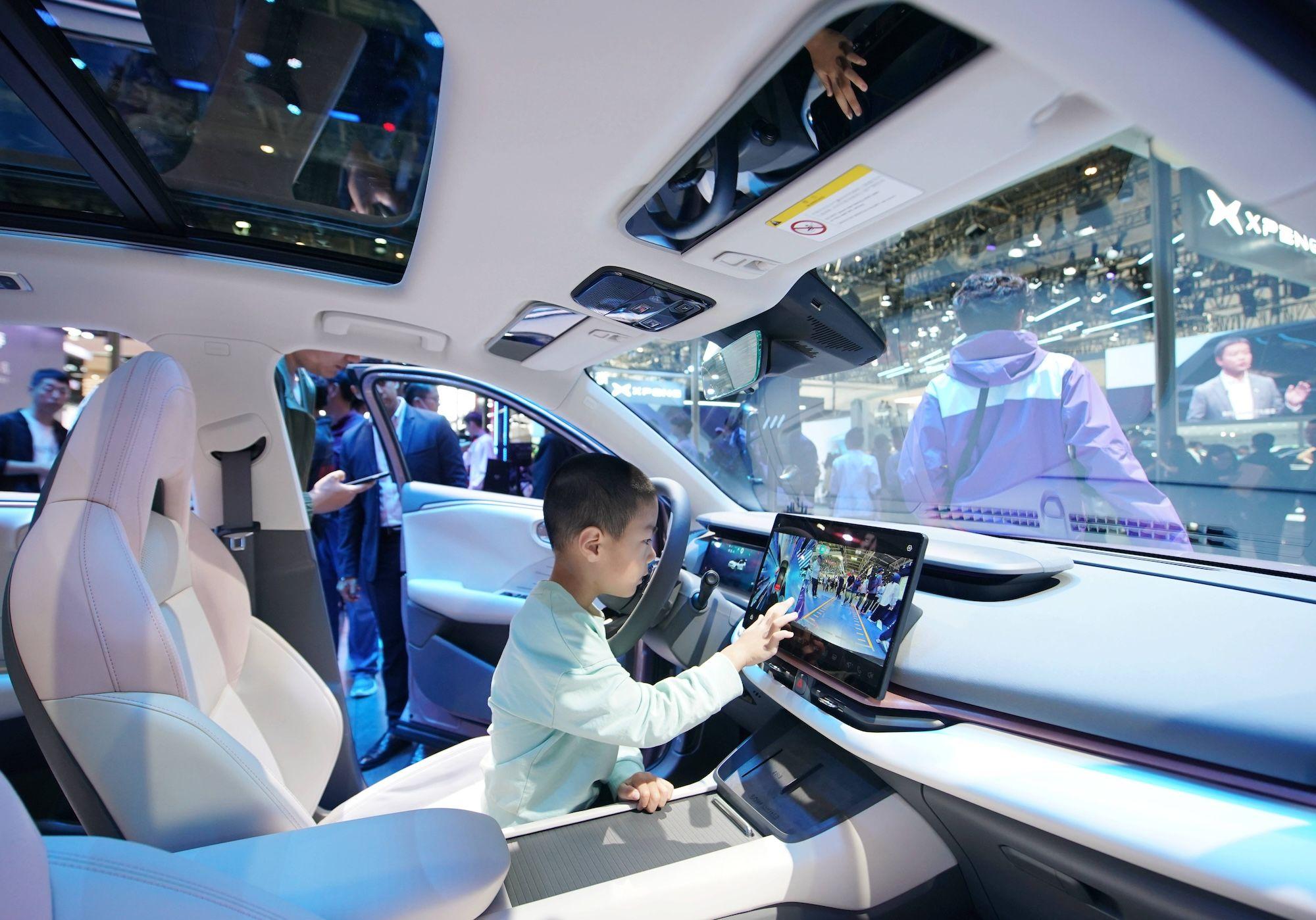 Ein Kind erlebt ein neues Energiefahrzeug von Lynk & Co auf der Internationalen Automobilausstellung 2024 in Peking