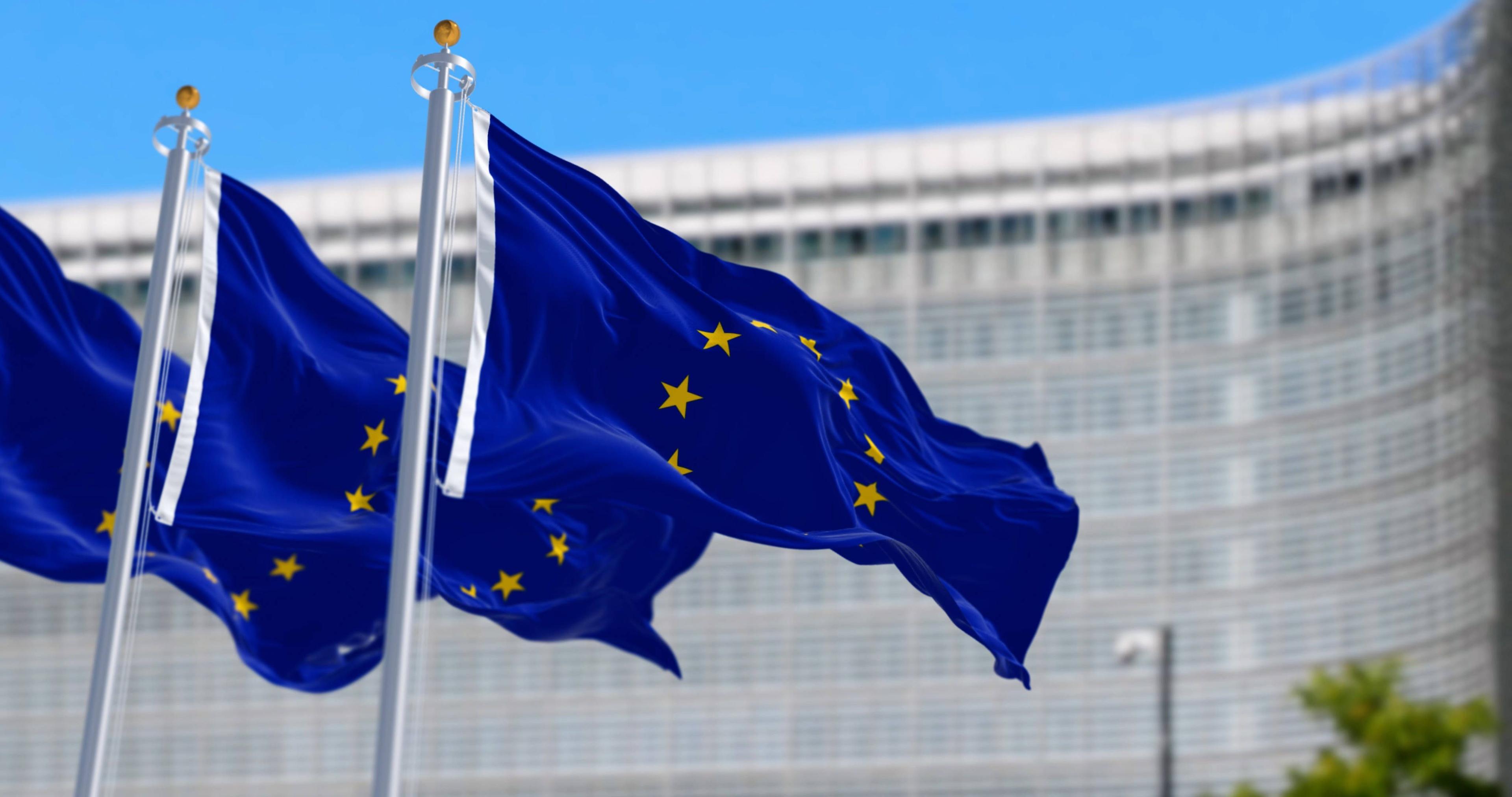 Die Flagge der Europäischen Union weht in Brüssel Die Flagge der Europäischen Union weht mit dem Sitz der Europäischen Kommission im Hintergrund. Politische und wirtschaftliche Union